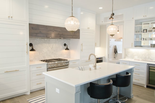 Interior of a modern white kitchen with a large island and chrome appliances
